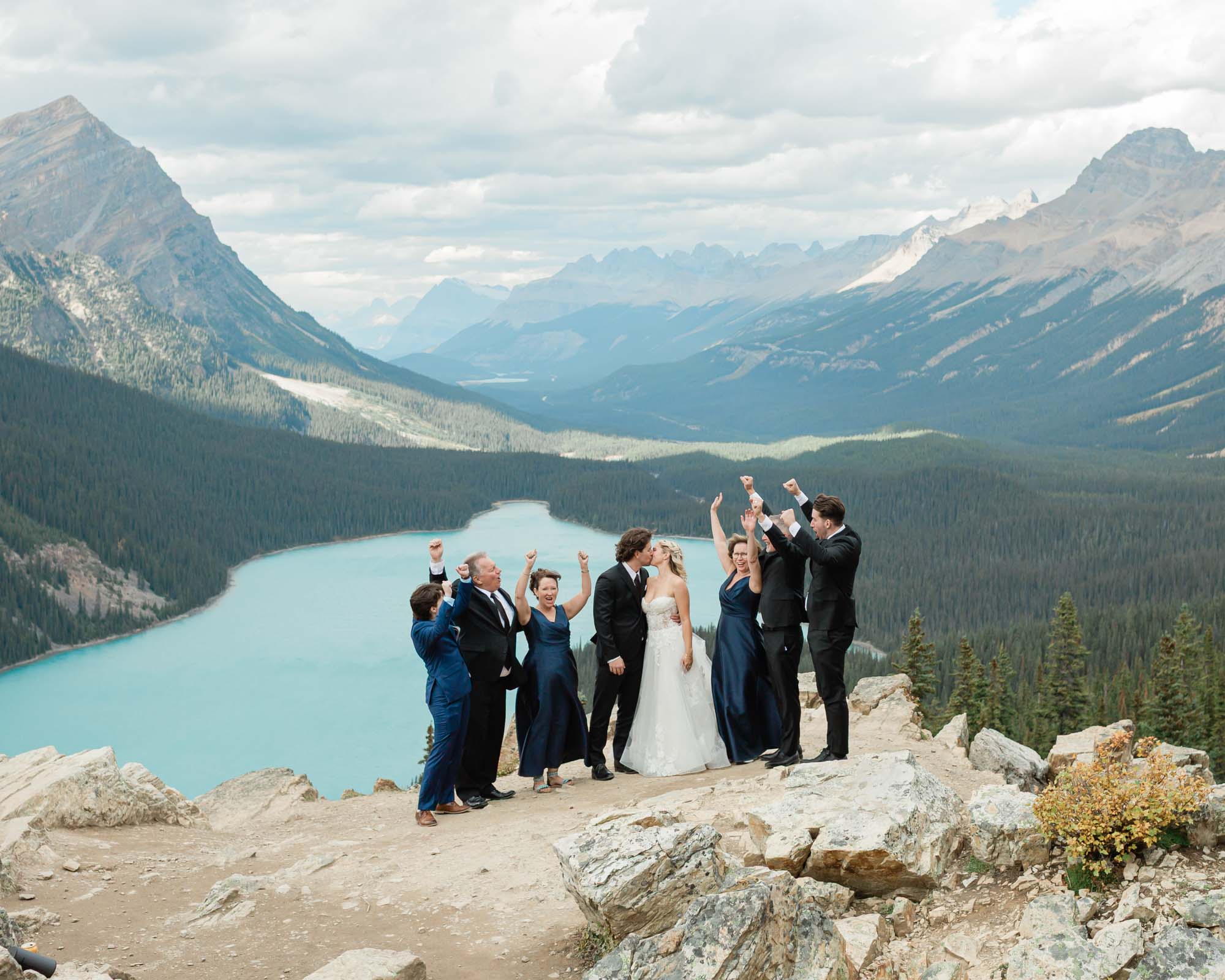 sarah, tyler and guests celebrating with their hands in the air in front of peyto lake after their banff wedding
