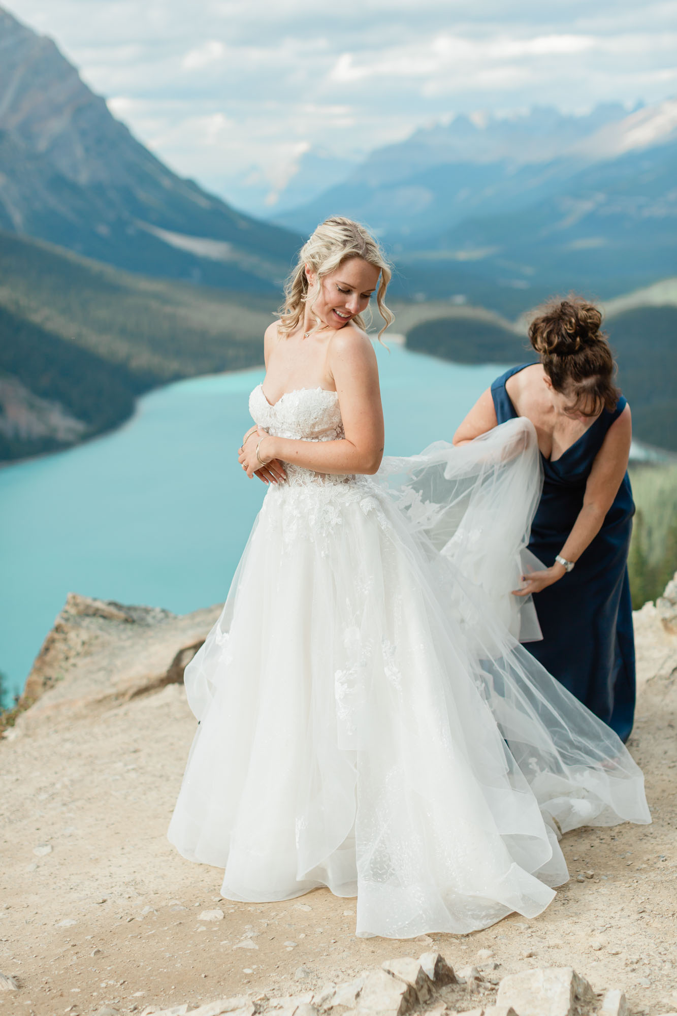sarah getting her dress fixed by her mom in front of Peyto lake