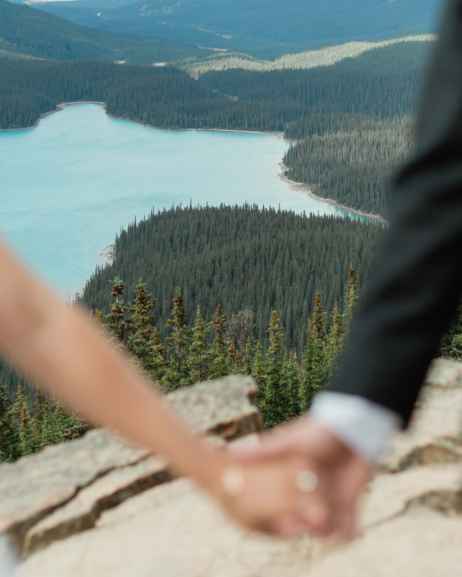 peyto lake in focus while the couple holds hands