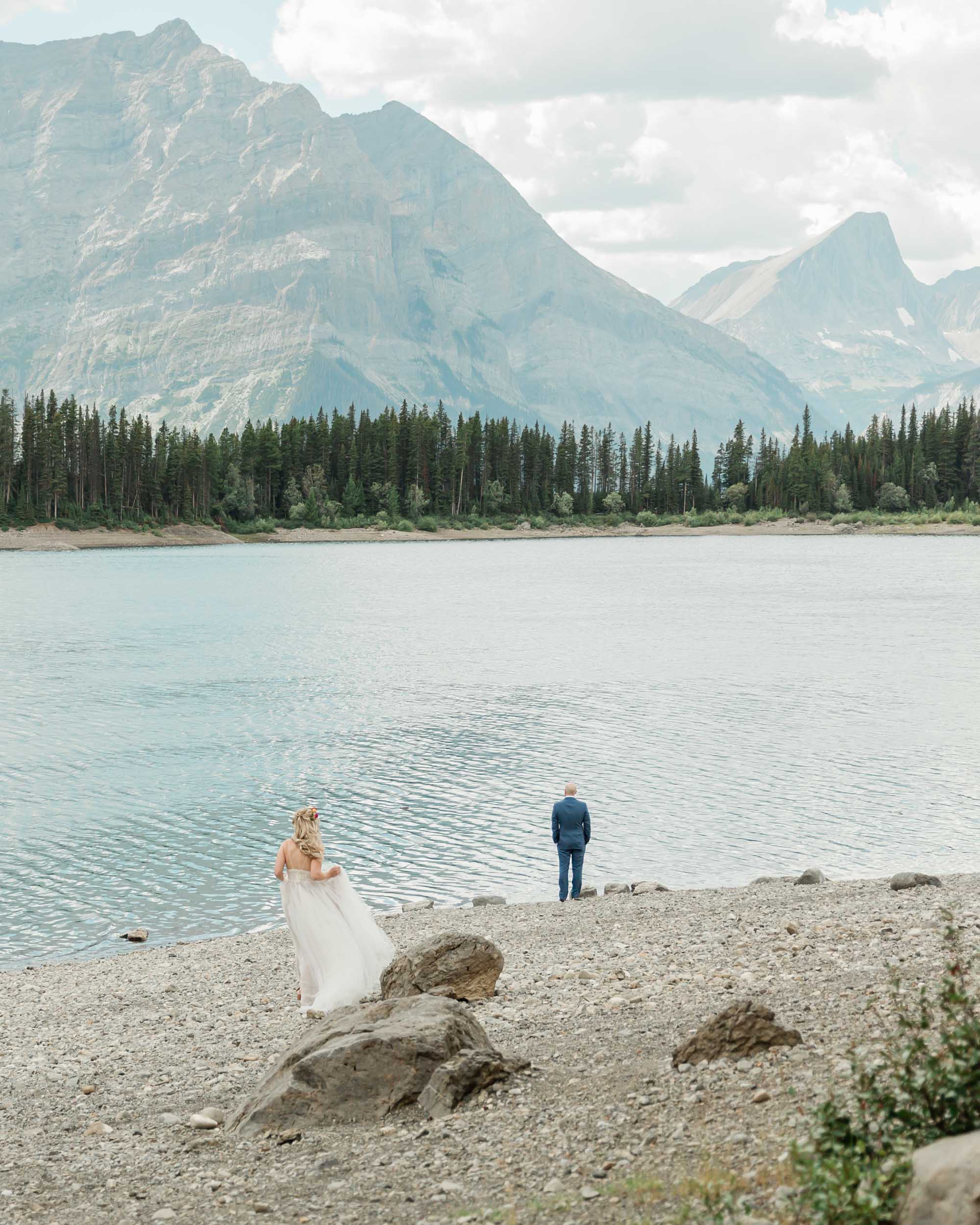 A bride walking towards her groom for their first look overlooking the mountains for their elopement