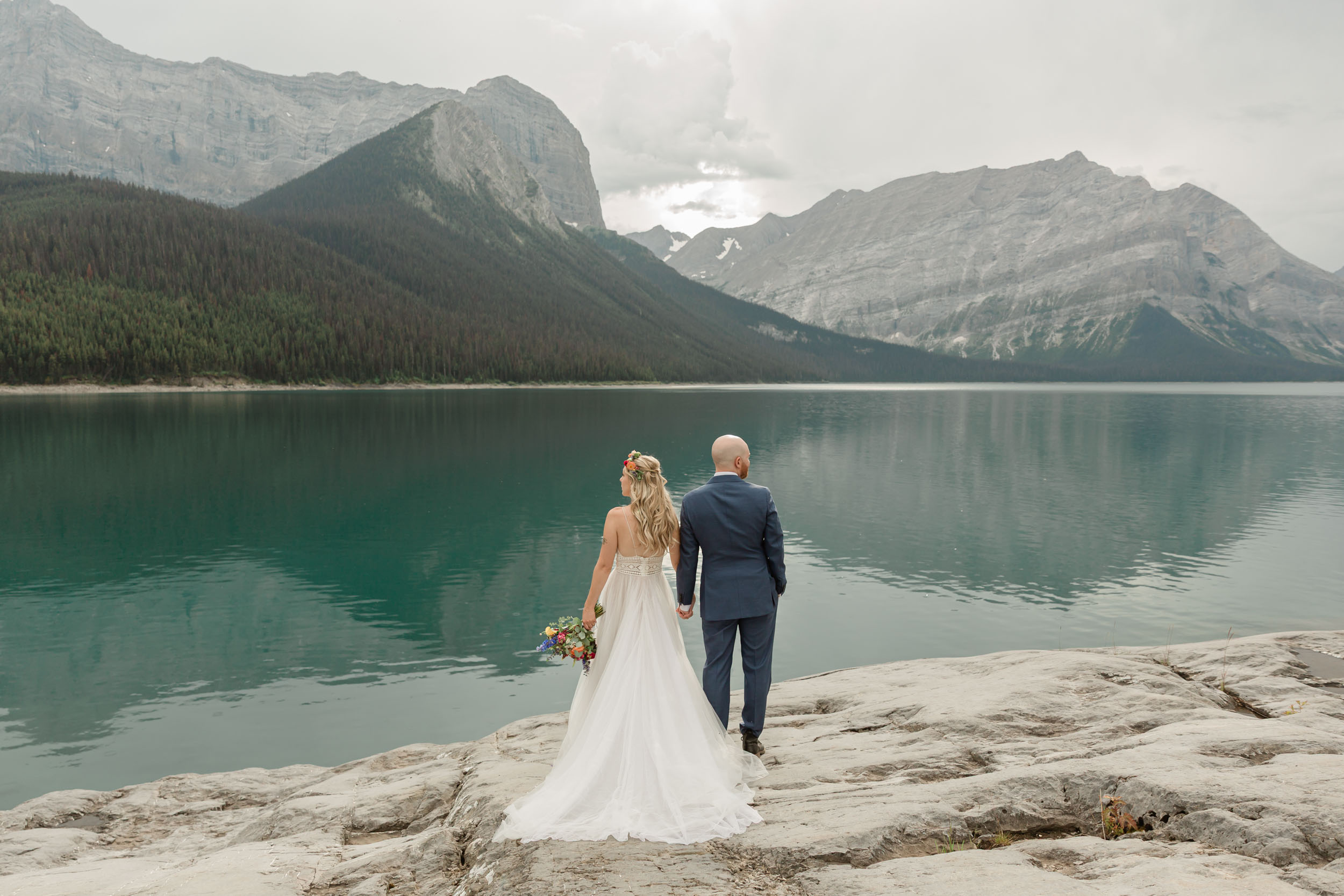 the couple posing for the camera during their mountain wedding near banff