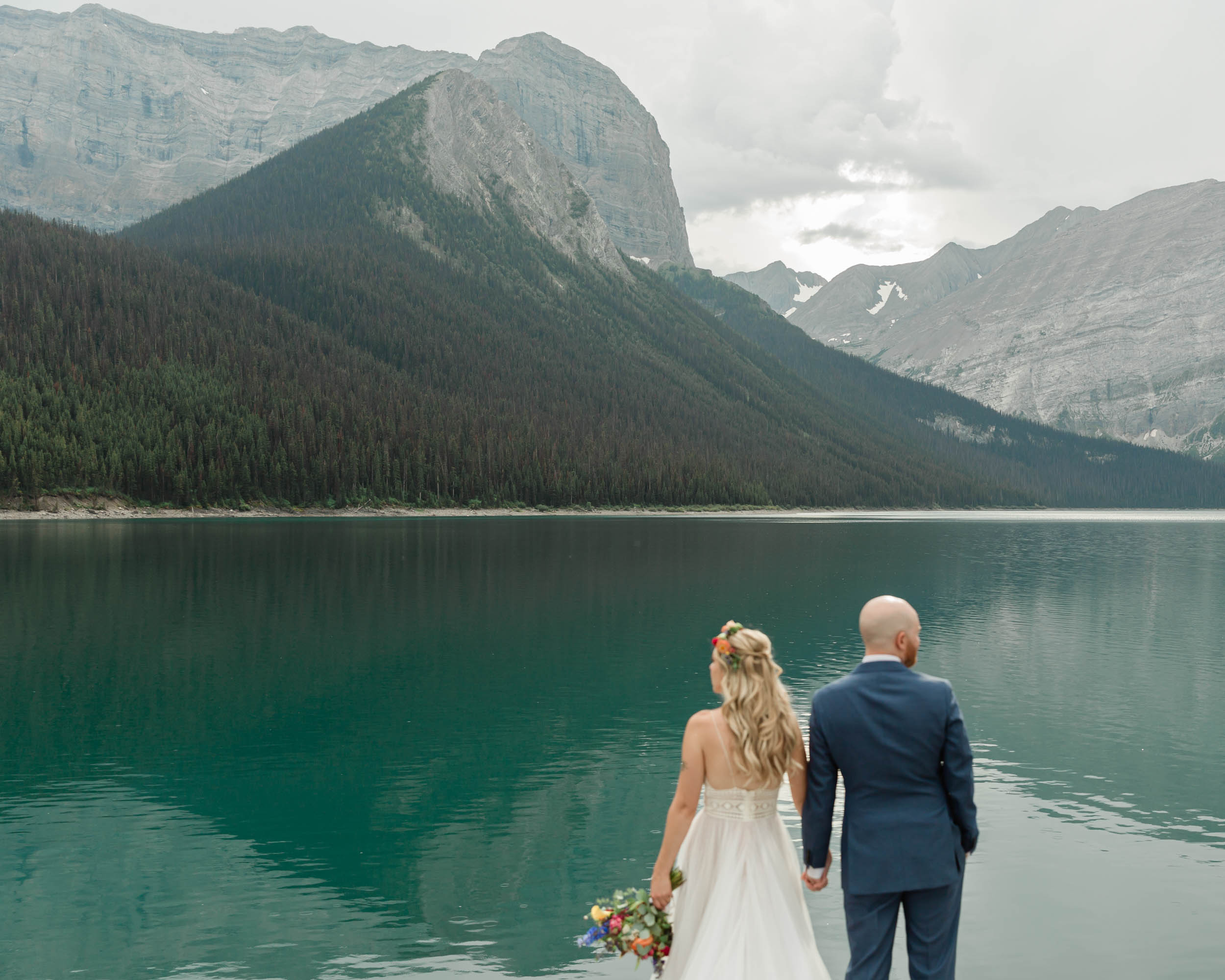 the couple posing for the camera during their mountain wedding near banff