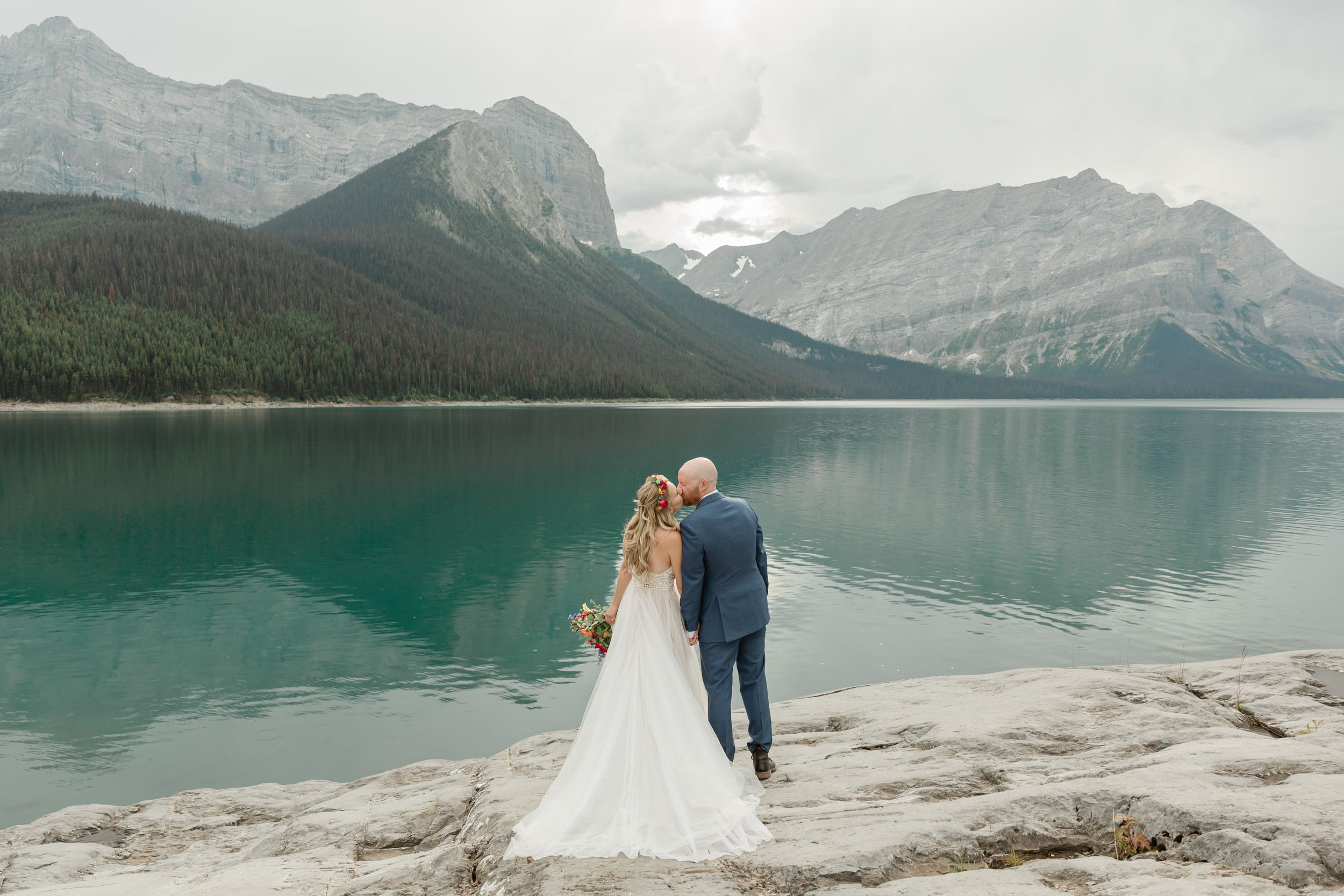 the couple posing for the camera during their mountain wedding near banff