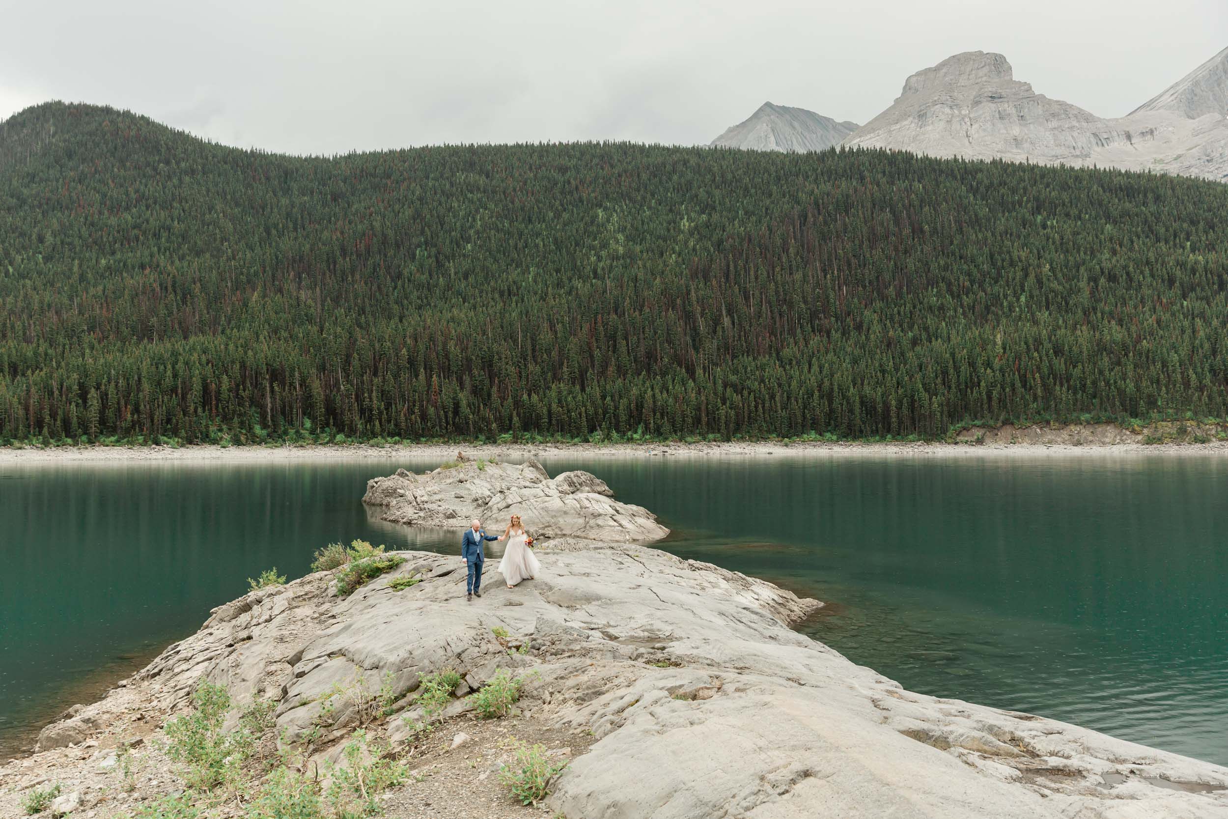 the couple posing for the camera during their mountain wedding near banff