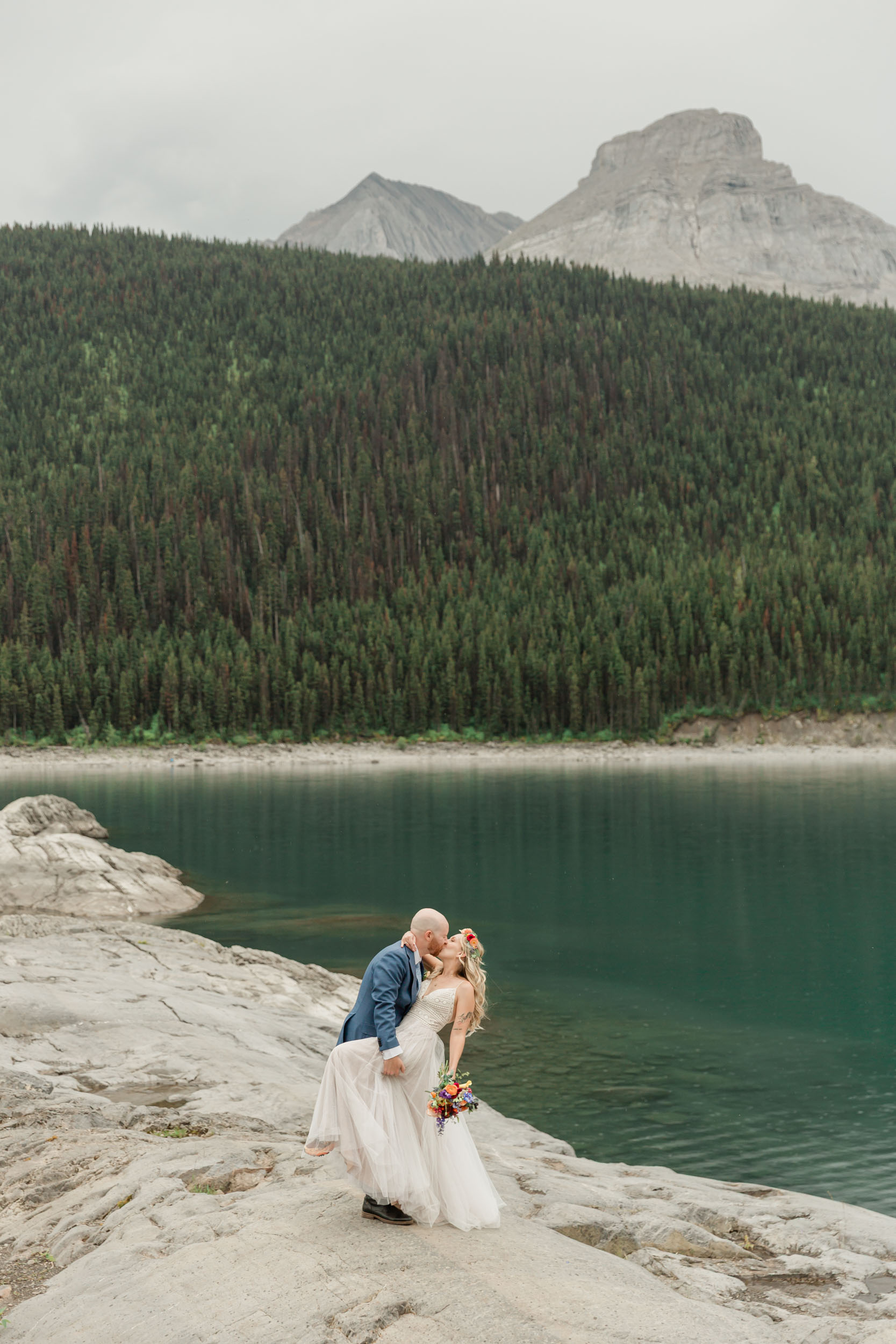 the couple posing for the camera during their mountain wedding near banff