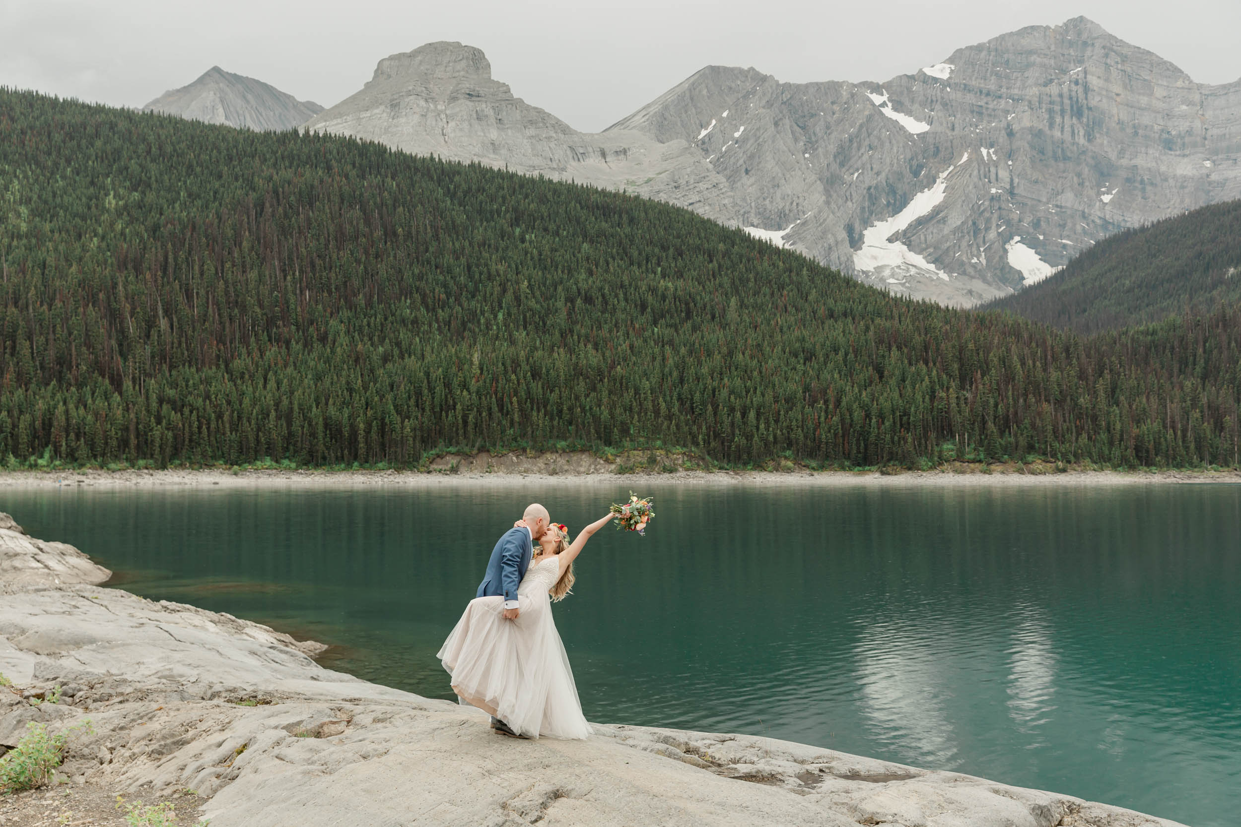 the couple posing for the camera during their mountain wedding near banff