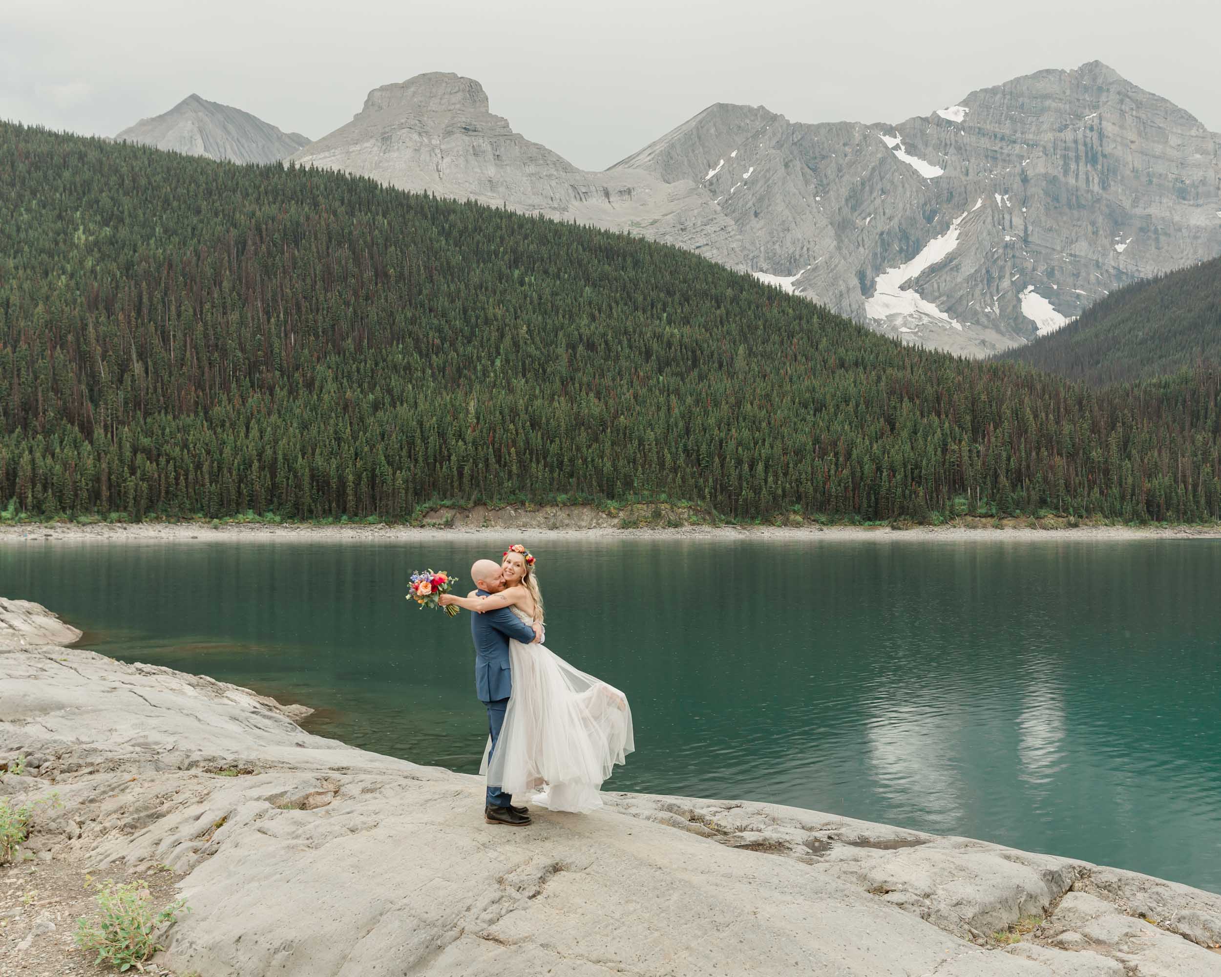 the couple posing for the camera during their mountain wedding near banff