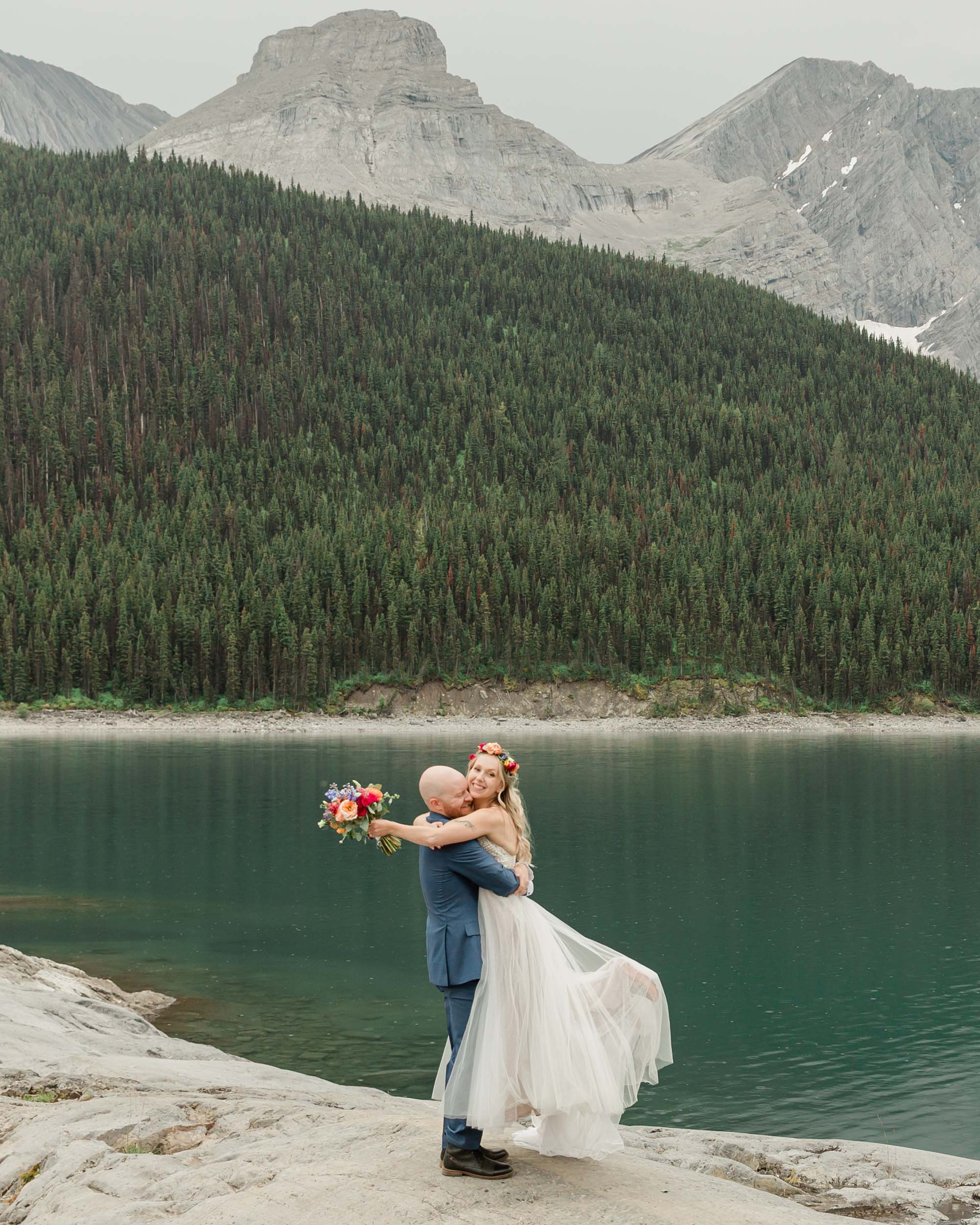 the couple posing for the camera during their mountain wedding near banff