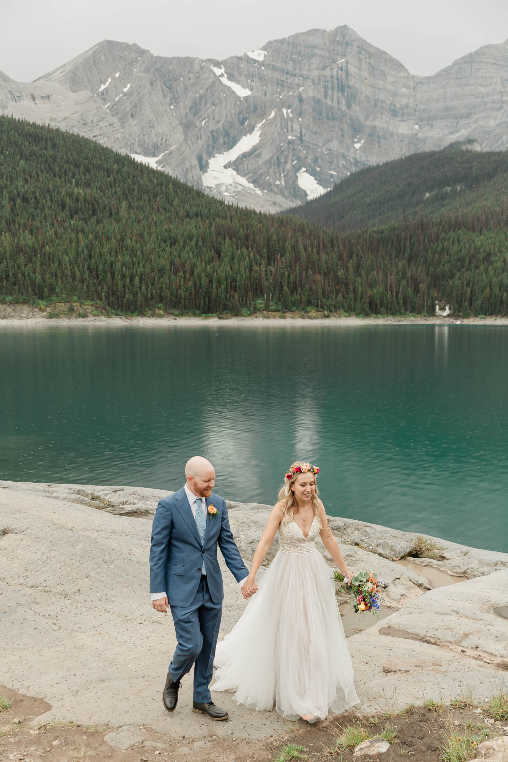 the couple posing for the camera during their mountain wedding near banff