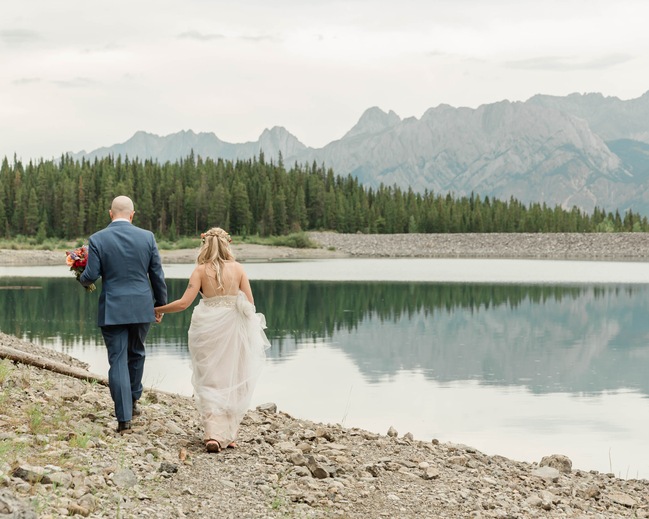 the couple posing for the camera during their mountain wedding near banff
