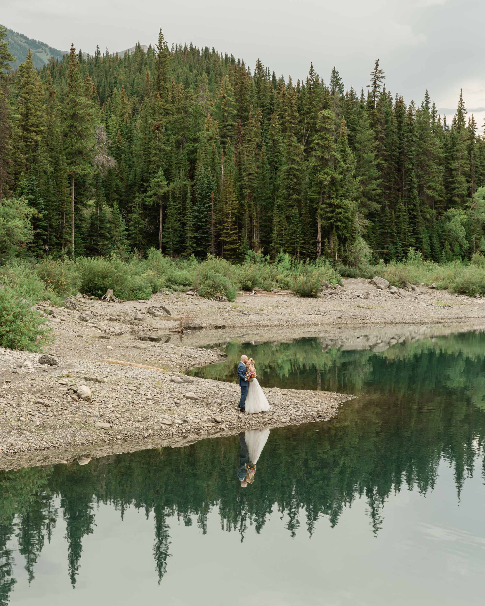 the couple kissing amongst an epic mountain landscape for their elopement in kananaskis