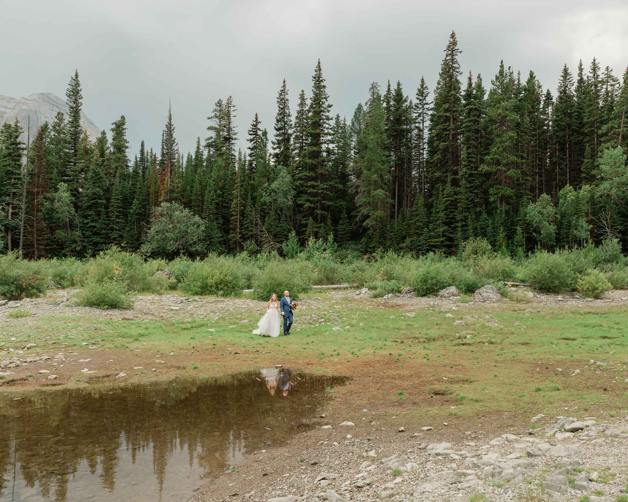 the couple posing for the camera during their mountain wedding near banff