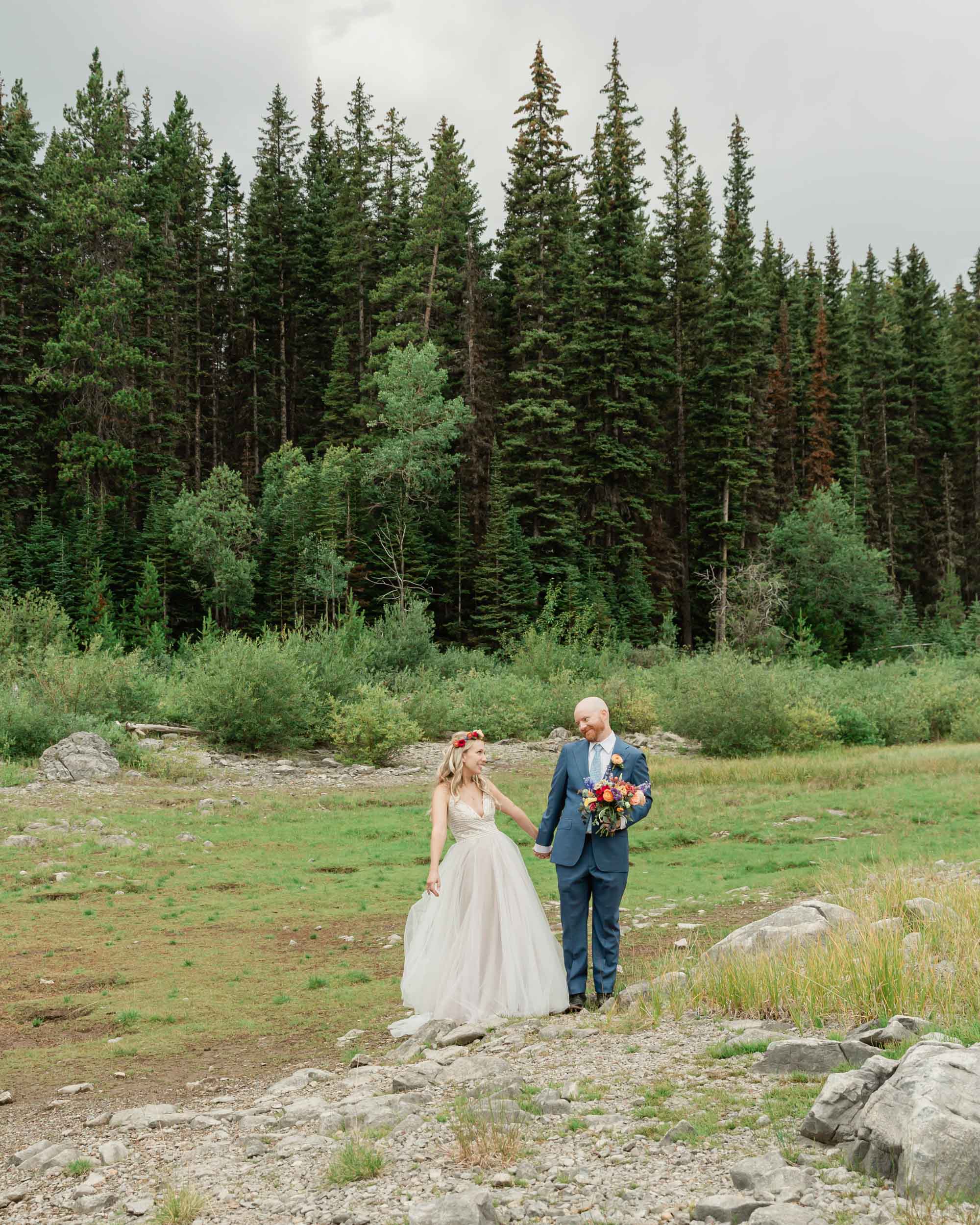 the couple posing for the camera during their mountain wedding near banff