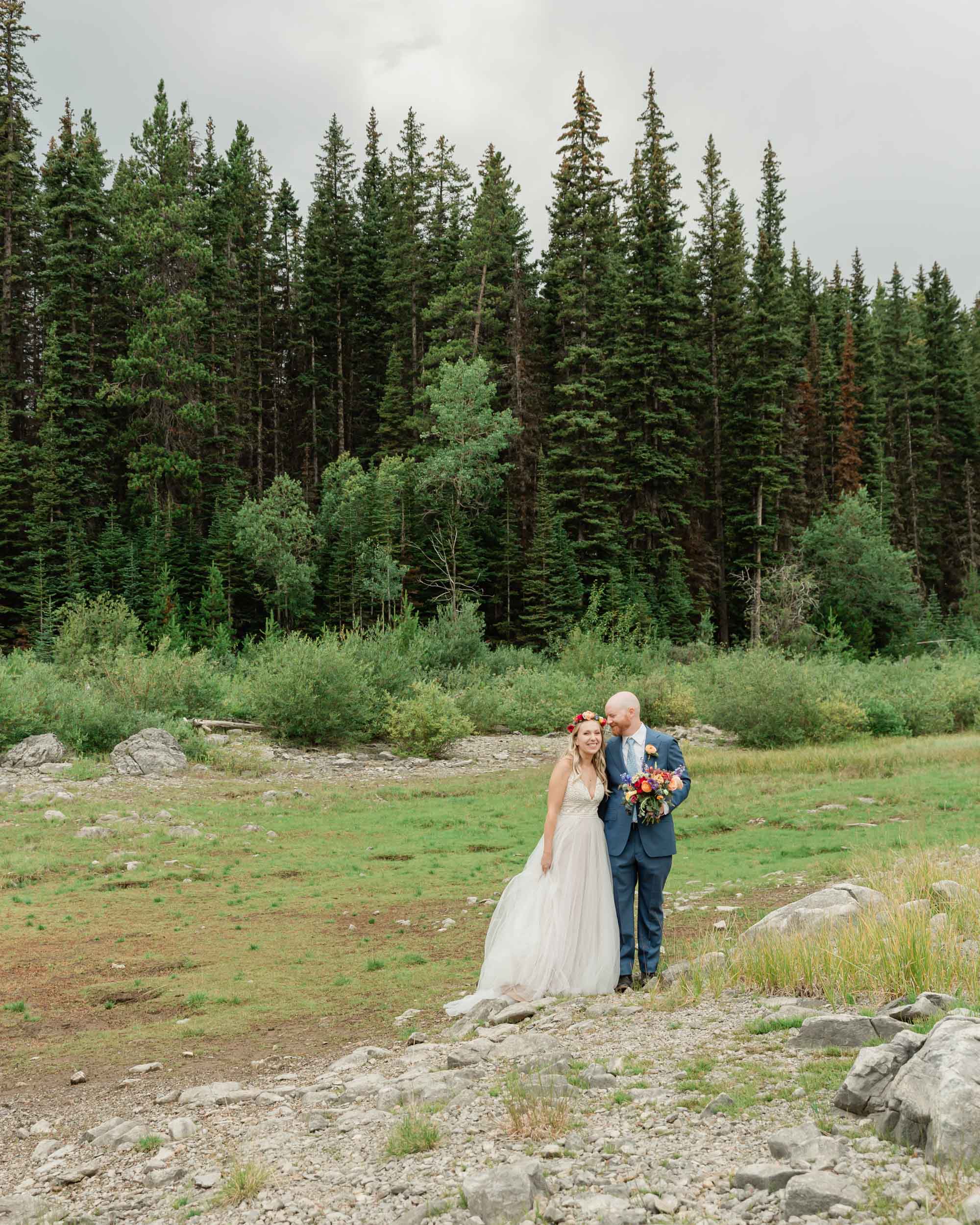 the couple posing for the camera during their mountain wedding near banff