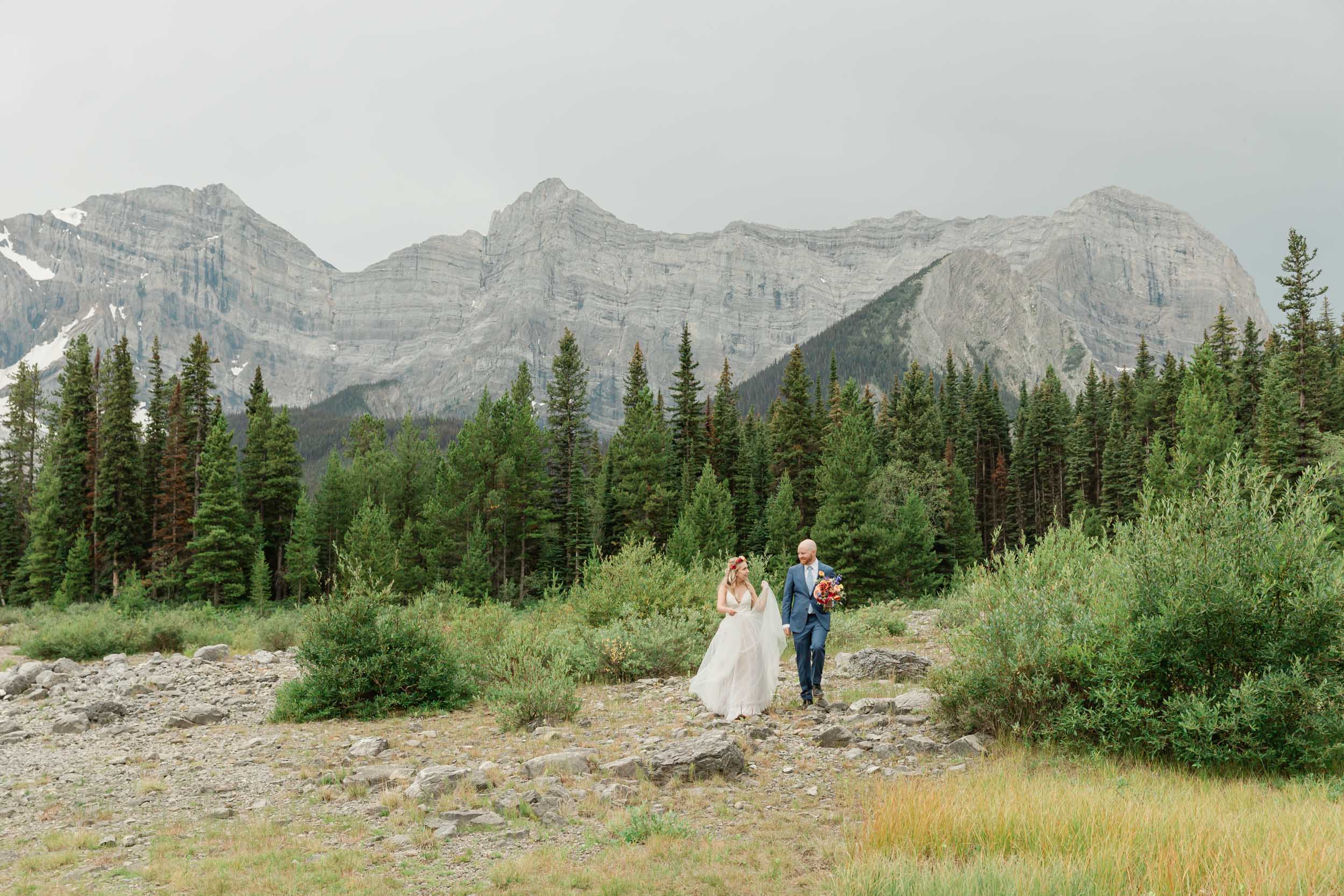 the couple posing for the camera during their mountain wedding near banff