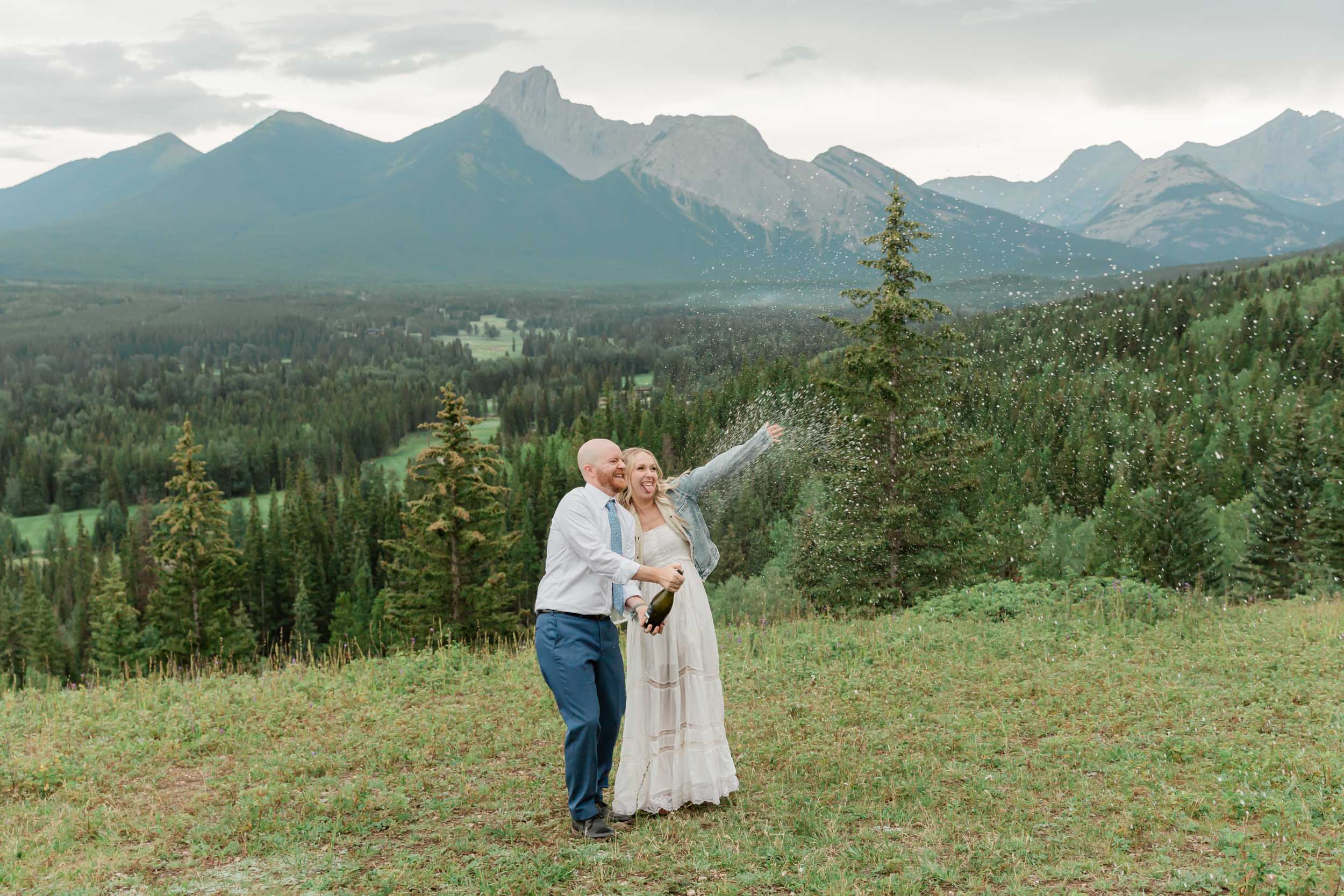 the couple celebrating after their intimate mountain elopement with champagne 