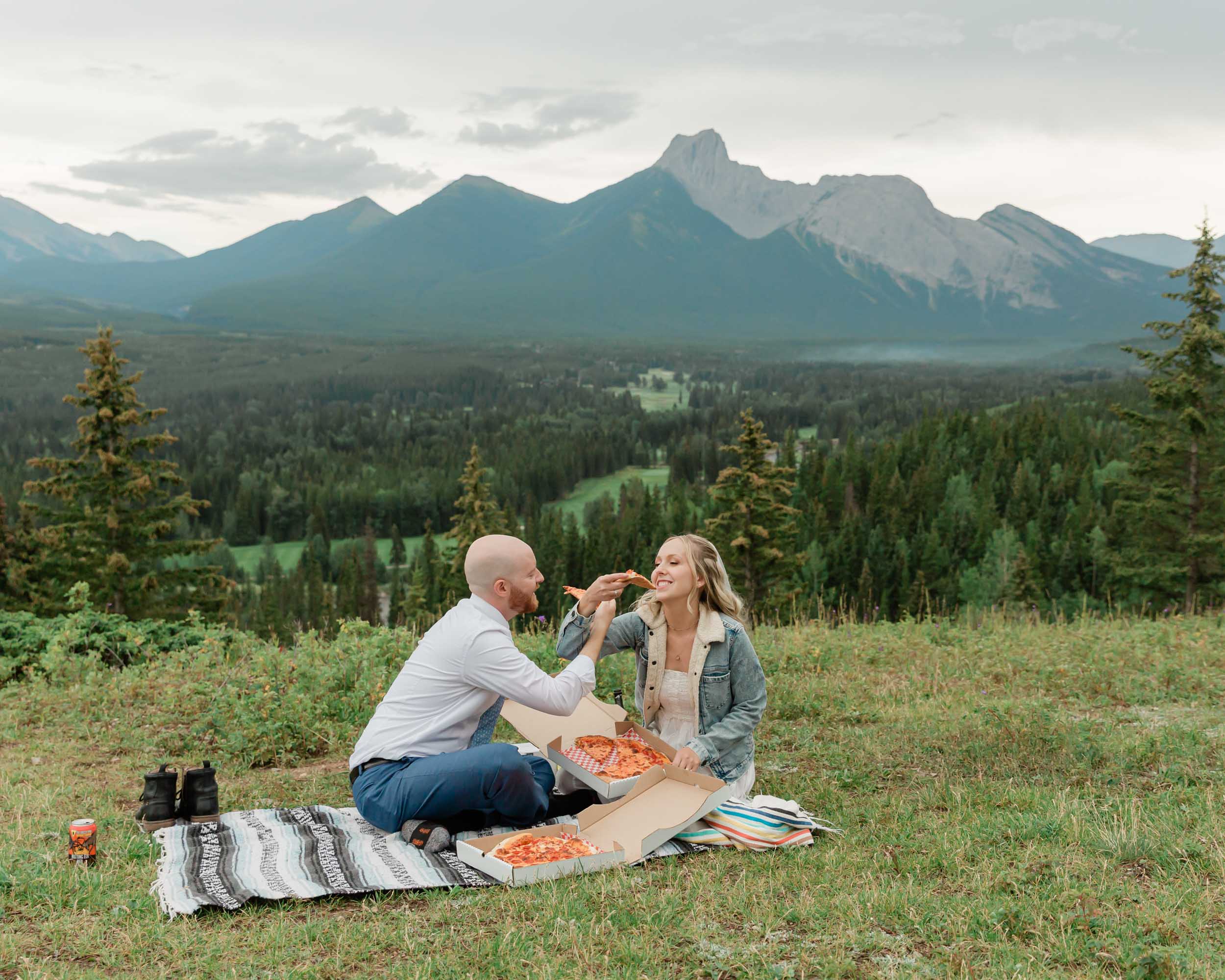 eating pizza celebrating after their ceremony during their mountain wedding near banff