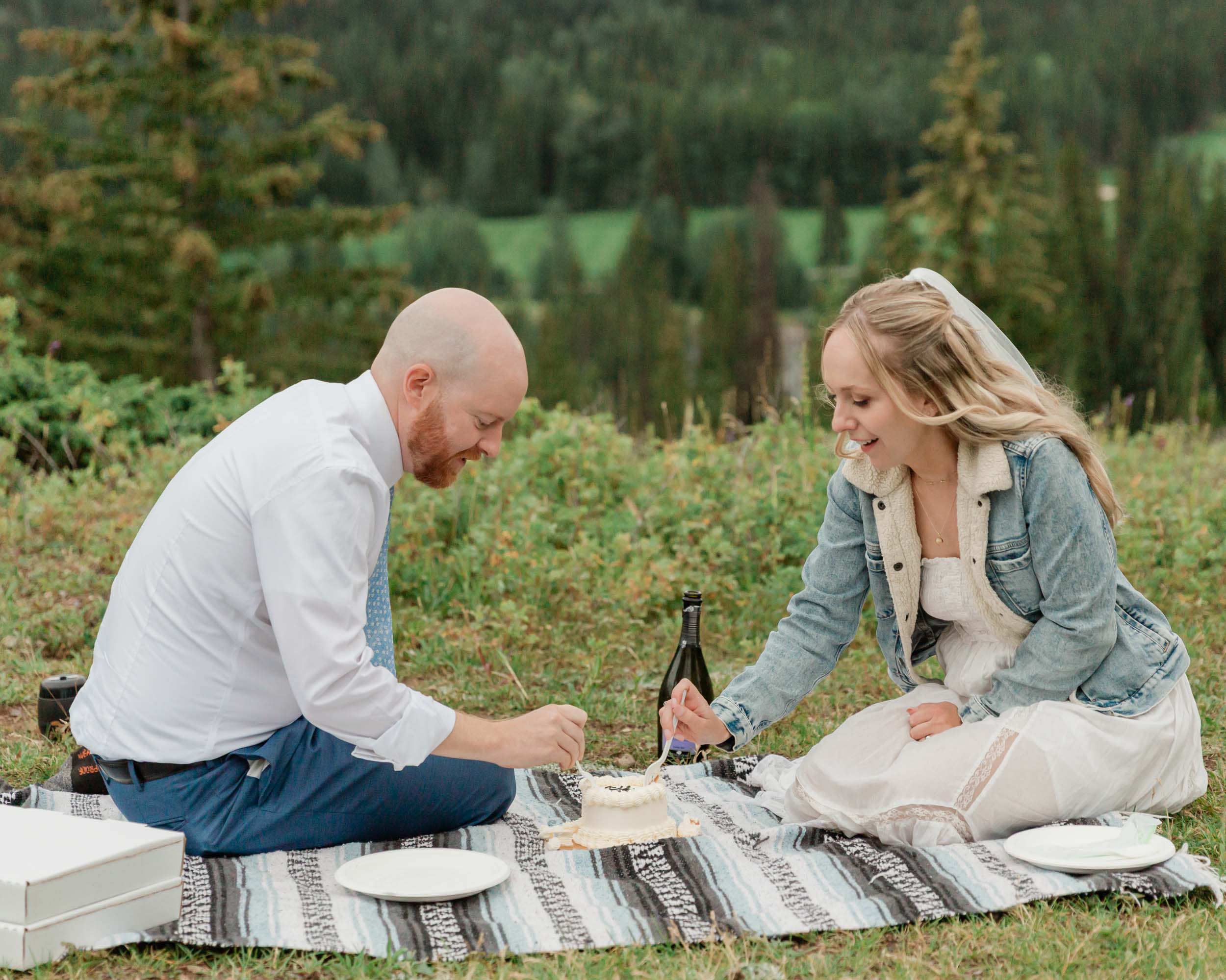 eating cake celebrating after their ceremony during their mountain wedding near banff