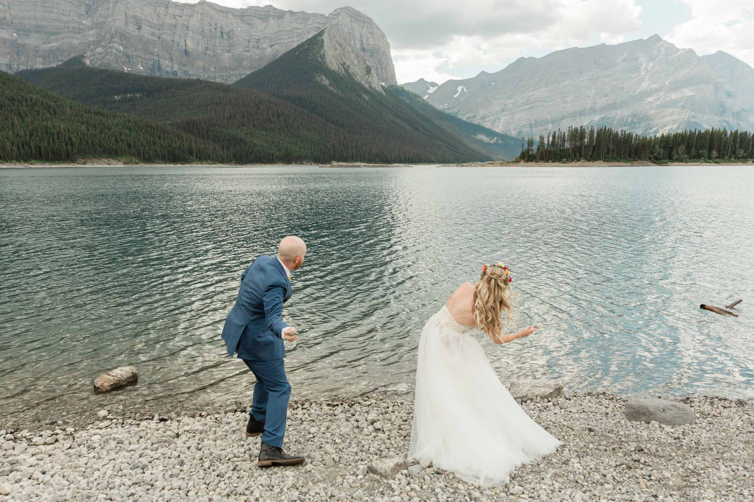 the couple skipping rocks during their kananaskis mountain elopement 