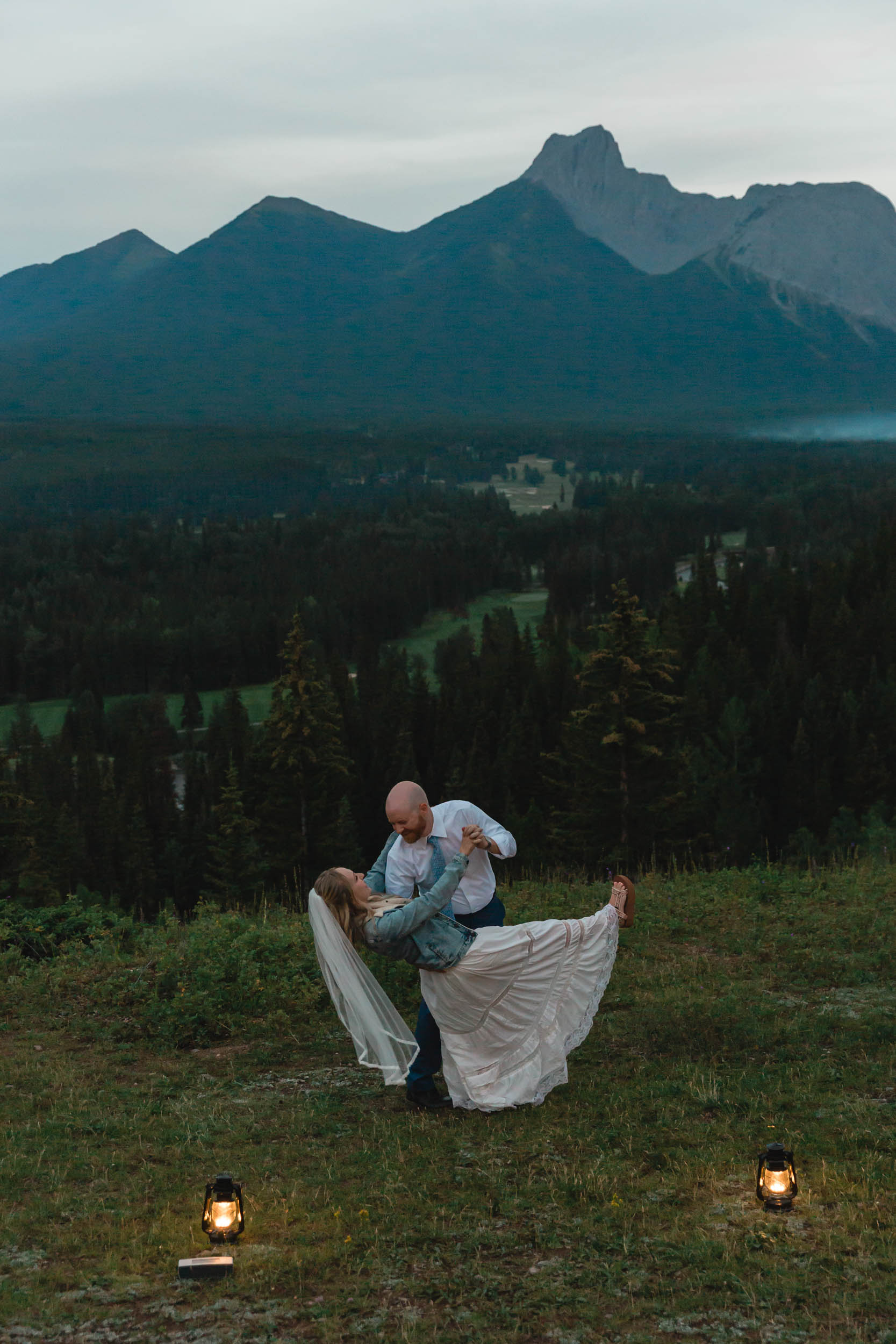 megan and scott embracing during their first dance with the banff mountain range behind them for their elopement day