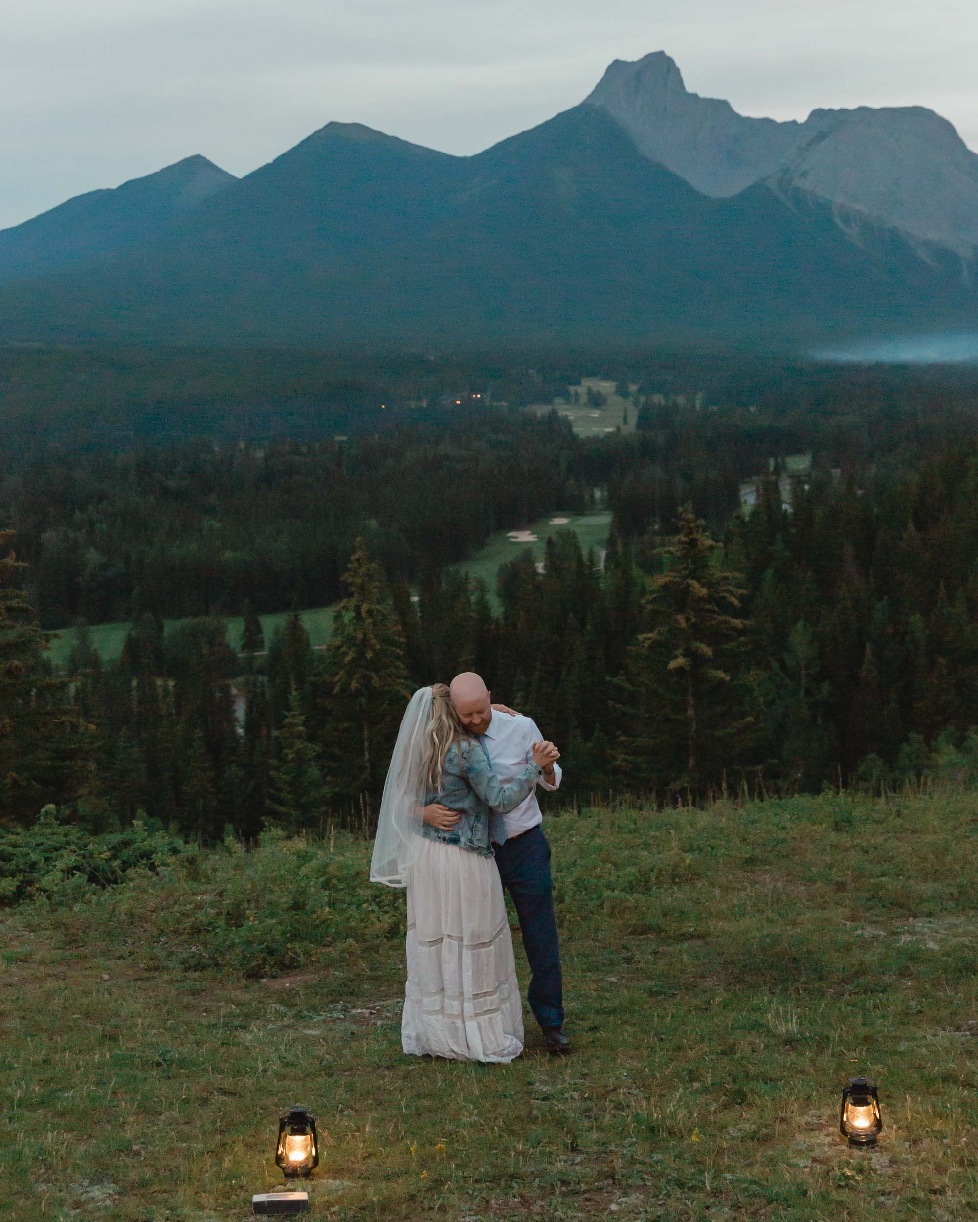 megan and scott embracing during their first dance with the banff mountain range behind them for their elopement day