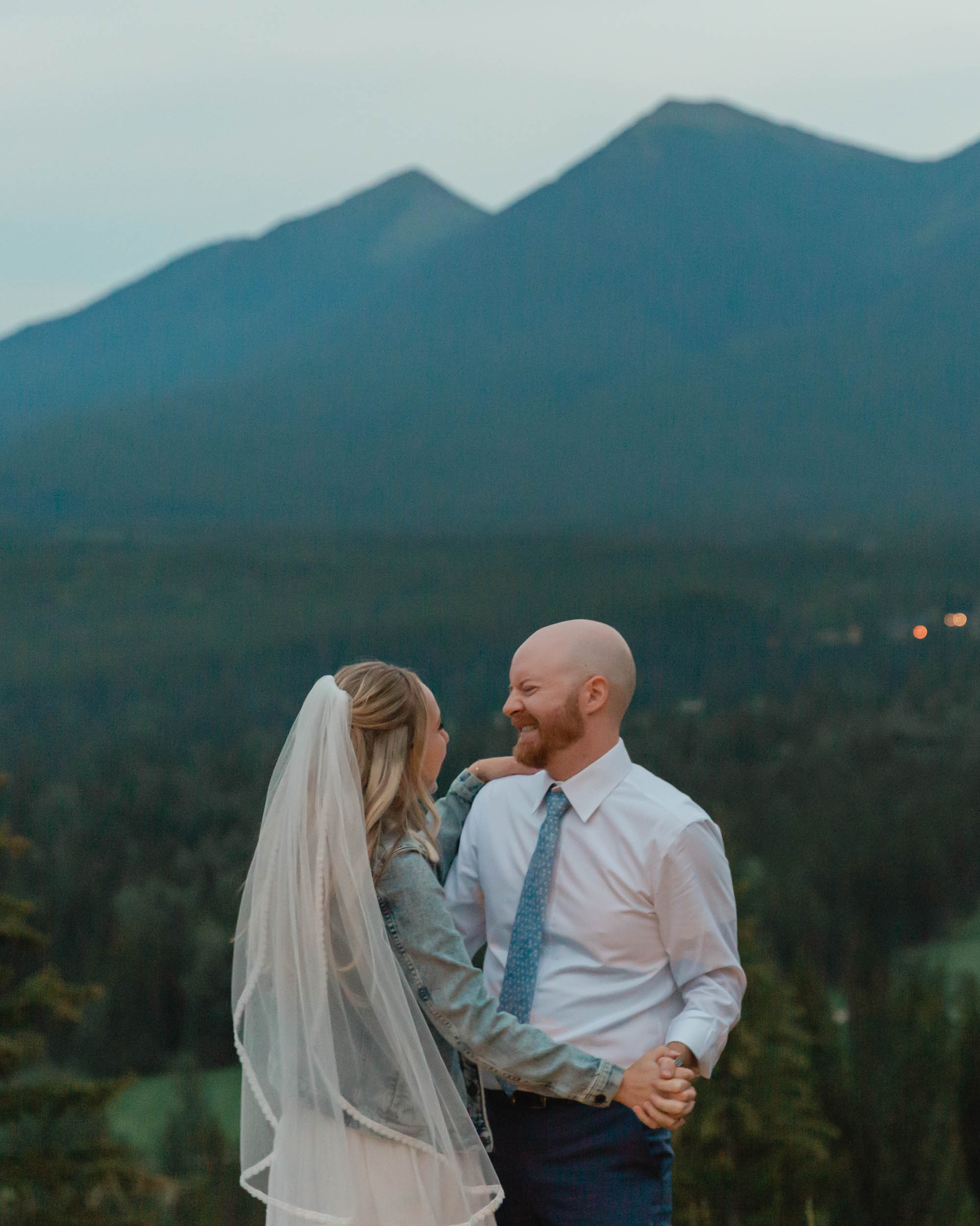 megan and scott embracing during their night time first dance with the banff mountain range behind them for their elopement day
