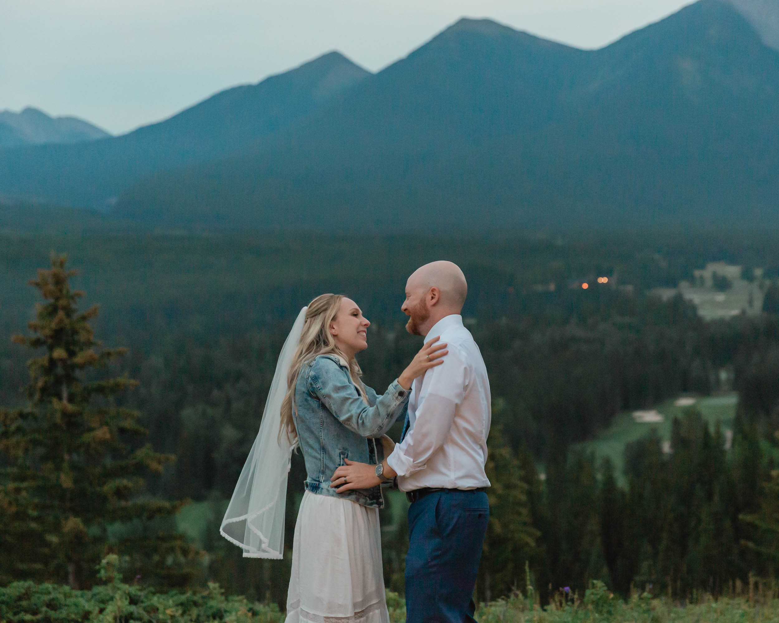 megan and scott embracing during their night time first dance with the banff mountain range behind them for their elopement day