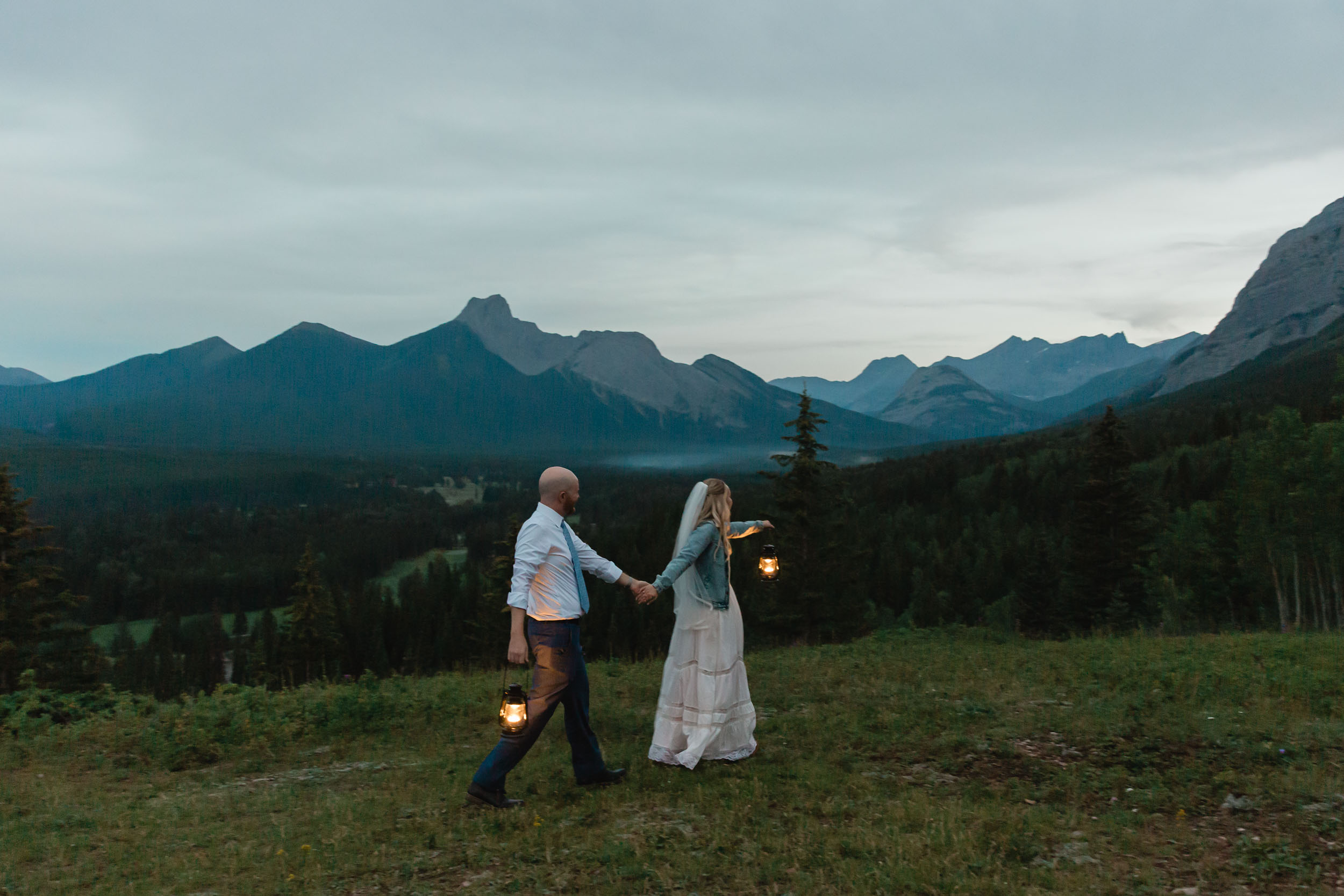 megan and scott embracing during their night time first dance with the banff mountain range behind them for their elopement day