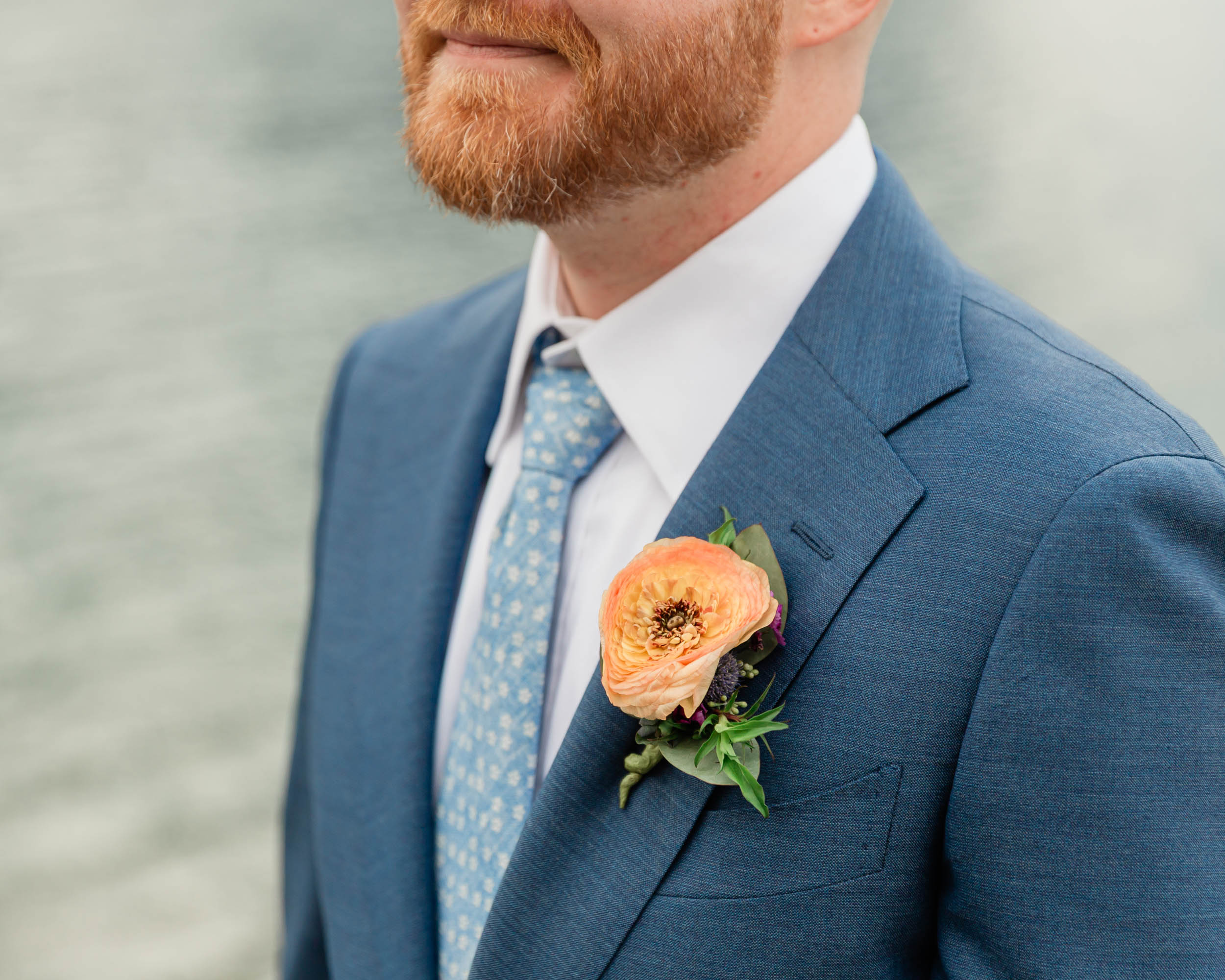 a close up of the grooms boutonniere 