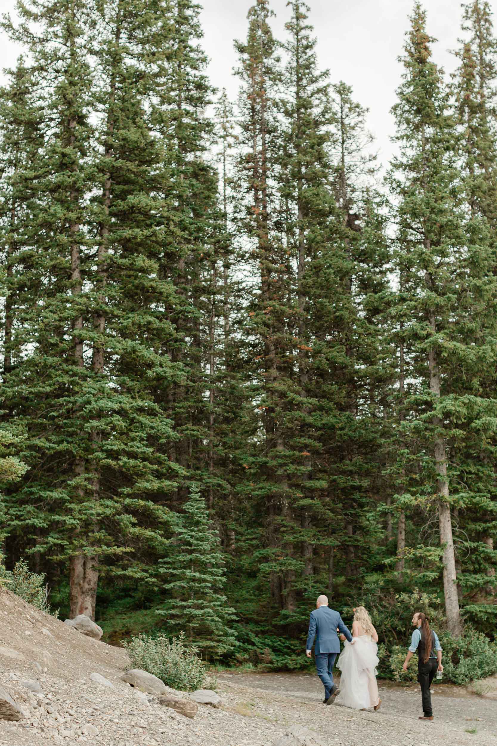 three people walking towards the parking lot before hiking out to their Banff wedding ceremony