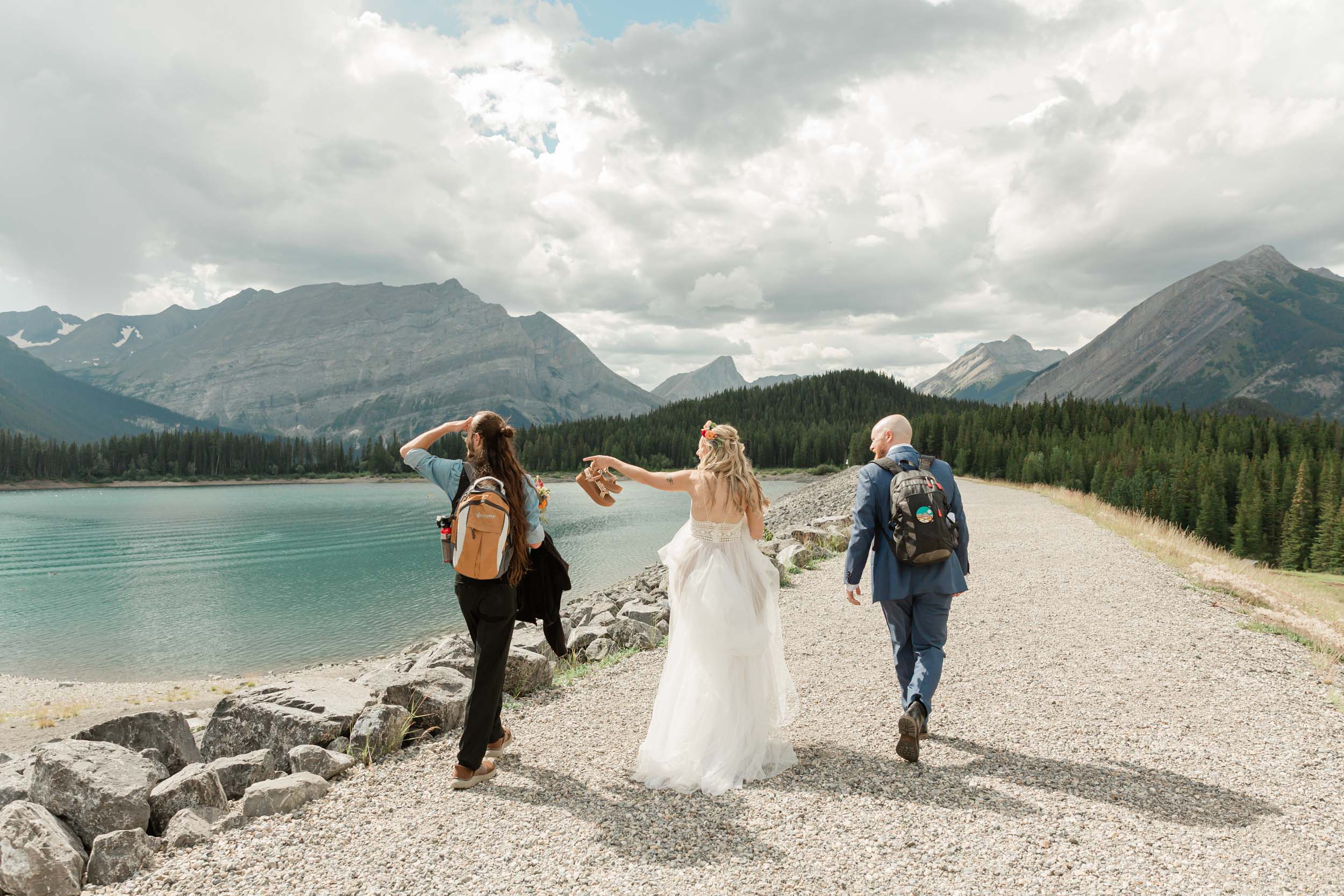 the bride and groom are walking with the brides brother towards their ceremony for their kananaskis mountain elopement 