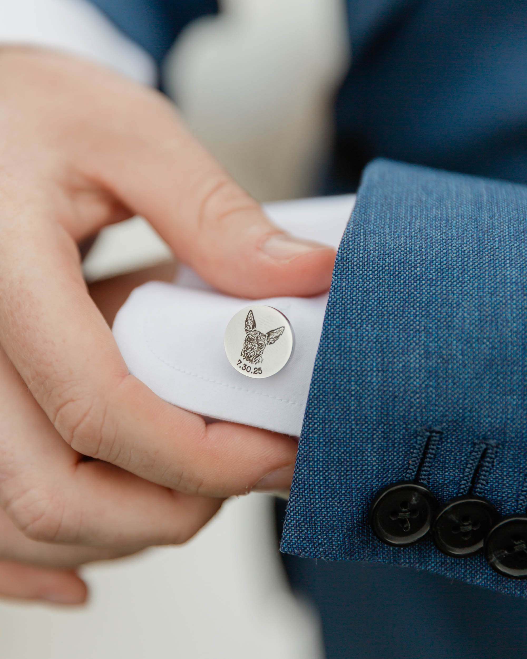 a close up of Scotts groom accessory a custom cufflink with his dog on it