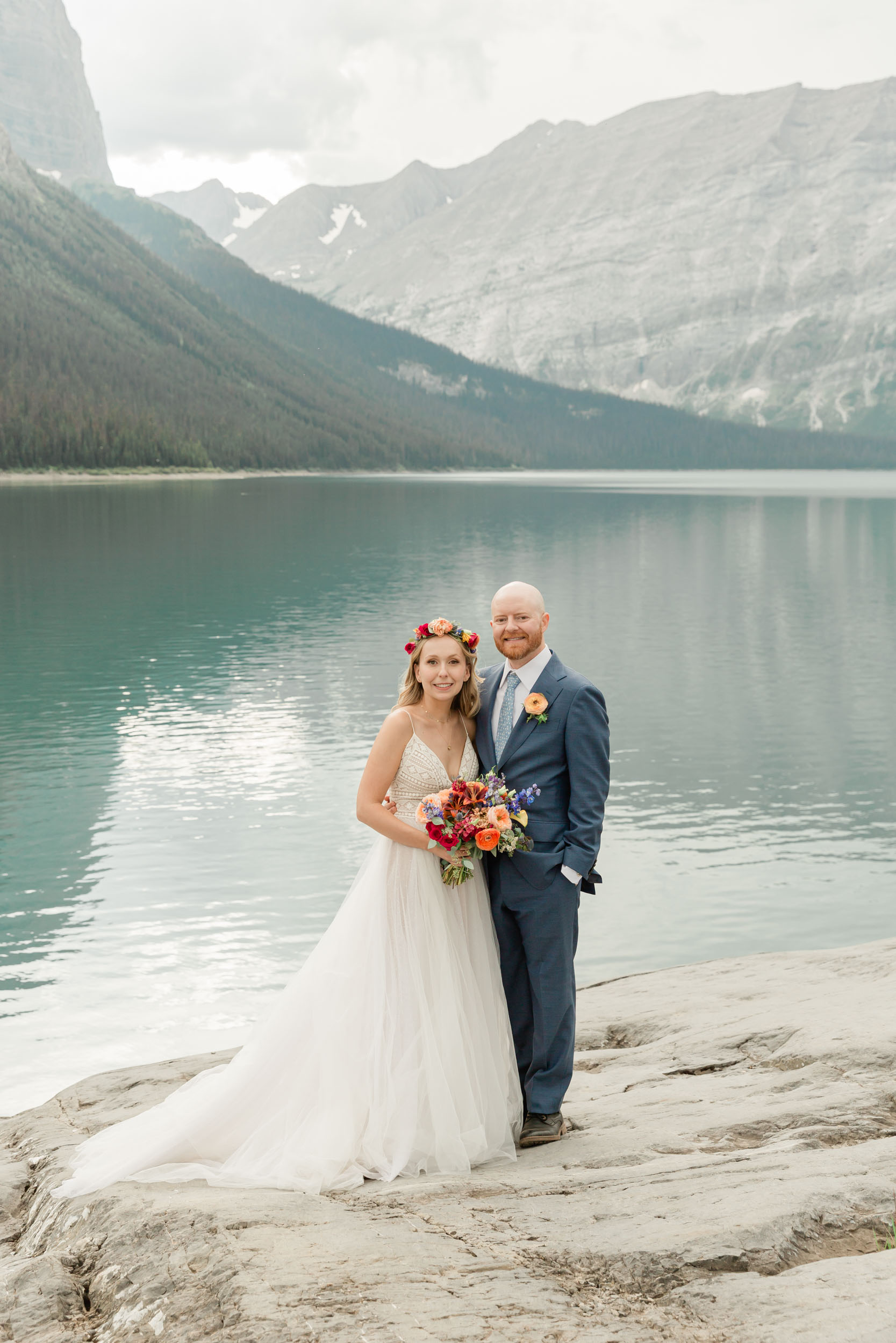 the couple posing for the camera during their mountain wedding near banff
