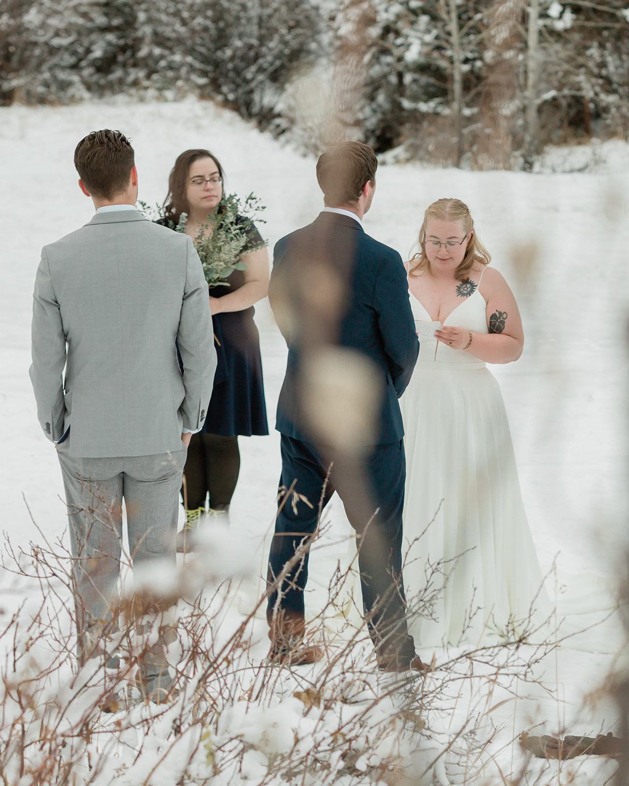 Bride reading her vows during an intimate Banff winter elopement ceremony surrounded by snow in Banff National Park.