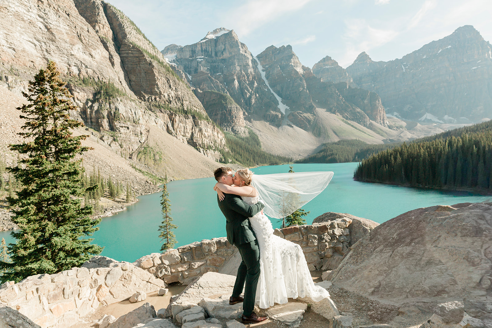Moraine Lake elopement couple kissing in front of the turquoise lake and Canadian Rocky Mountains in Banff National Park.