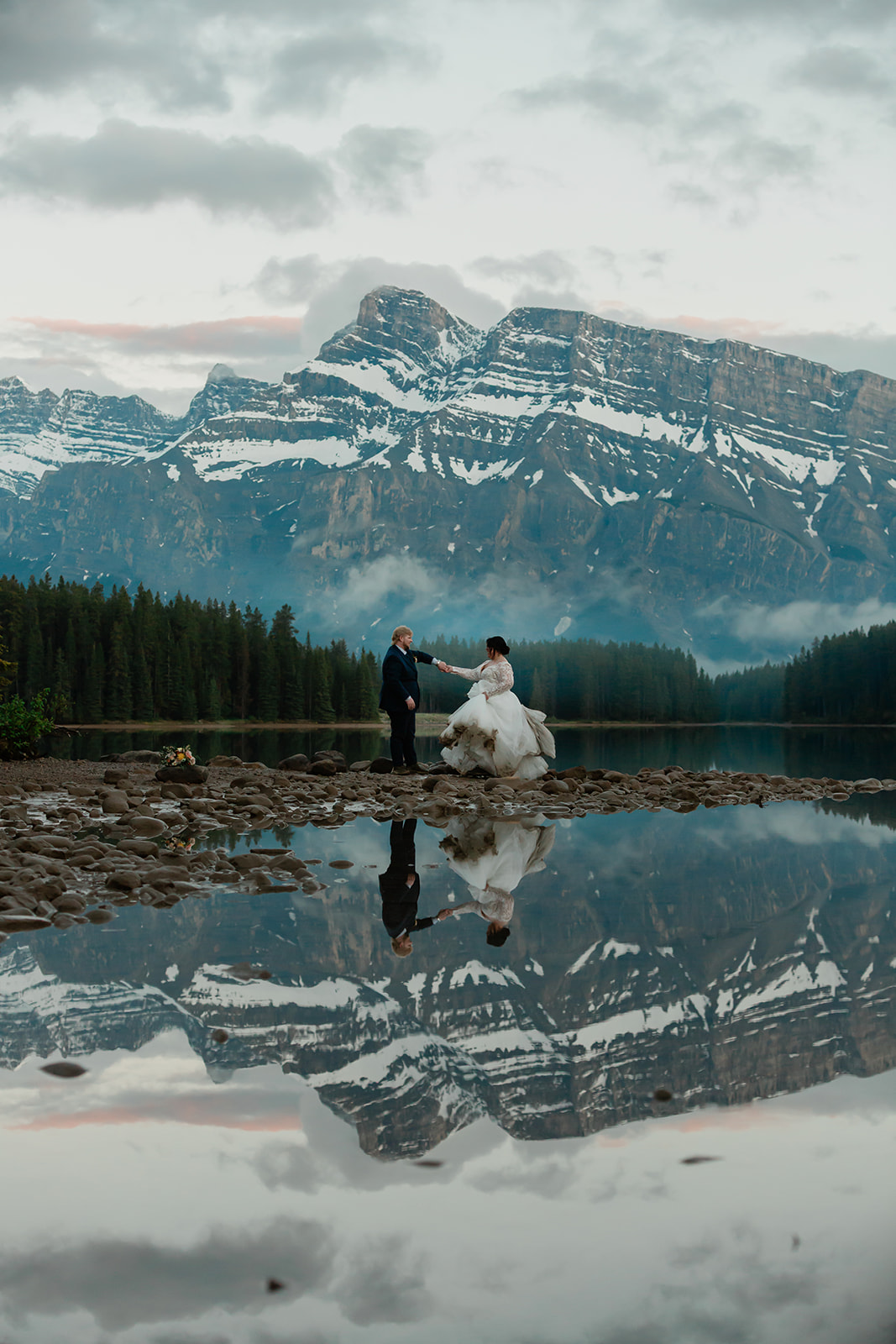See Rachel and Russell’s Lake Minnewanka elopement, from an intimate Banff ceremony and rainbow to Two Jack Lake, dancing, and star photos.