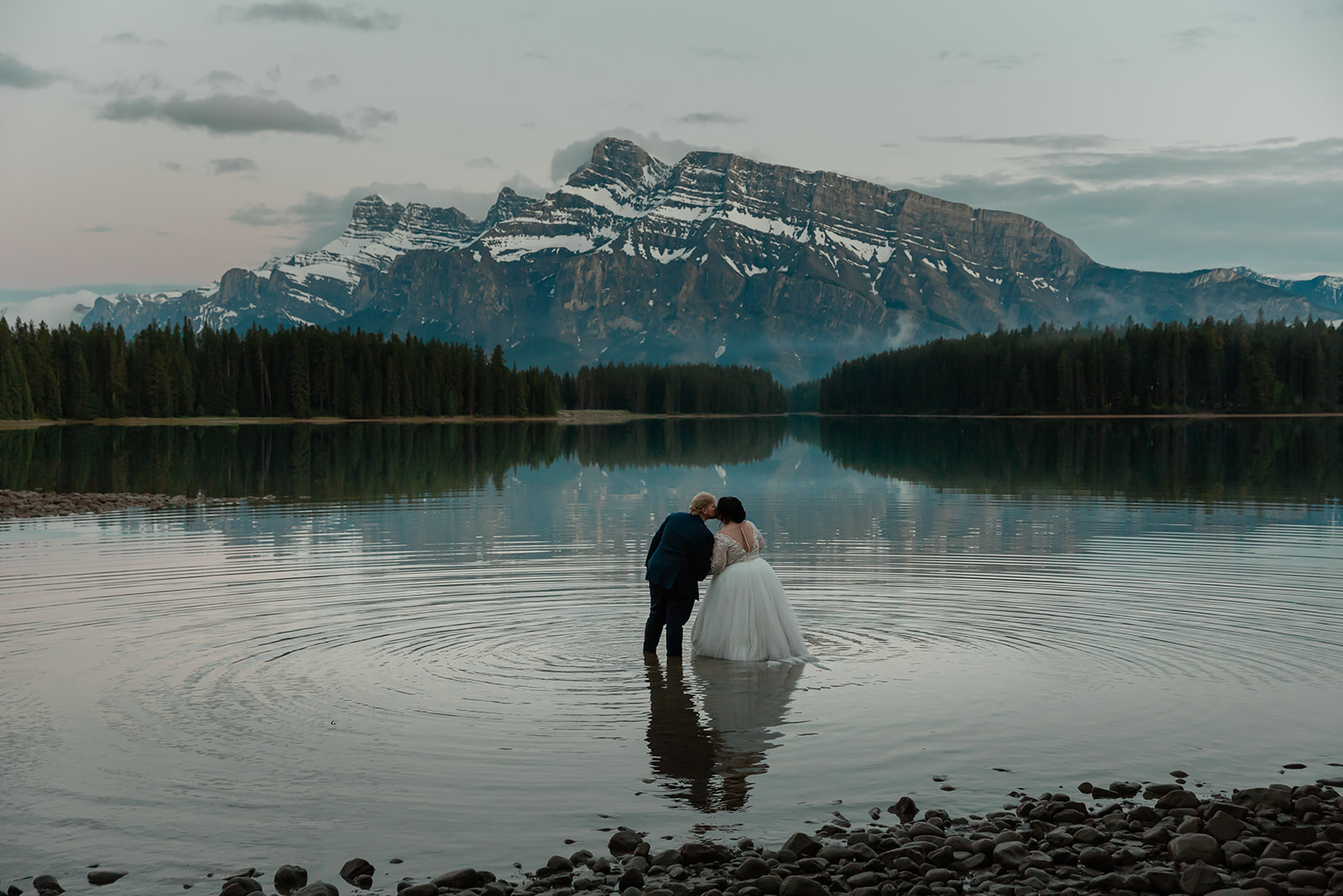 See Rachel and Russell’s Lake Minnewanka elopement, from an intimate Banff ceremony and rainbow to Two Jack Lake, dancing, and star photos.